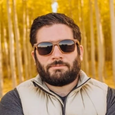 A headshot of David Zumini with yellow trees in the background.
